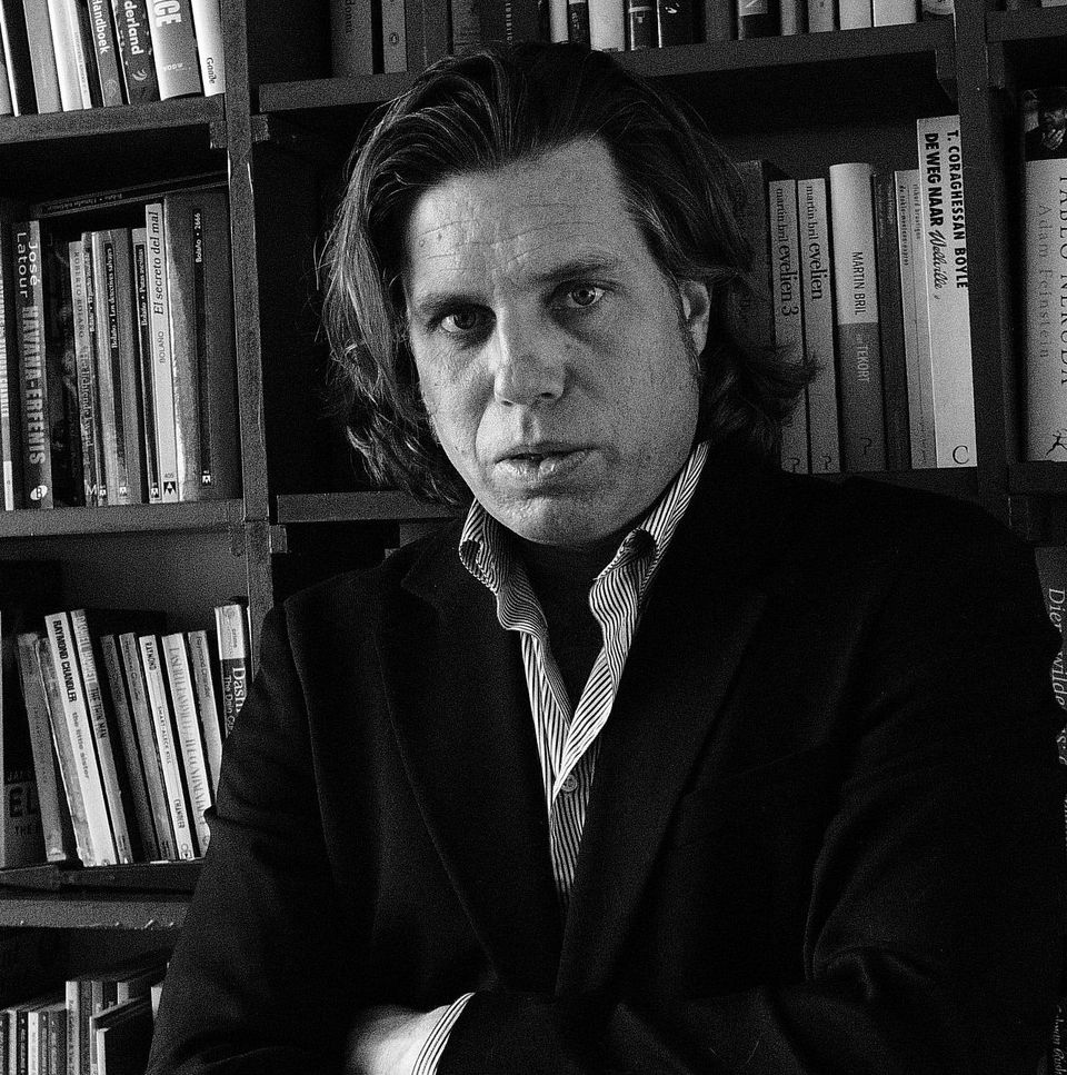 Ivo Teulings, in zwart-wit, voor een boekenkast